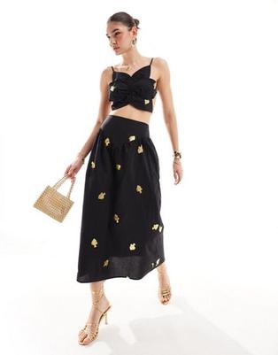 Oferta de Never Fully Dressed Marra drop hem cotton maxi skirt co-ord in black por $79 en ASOS