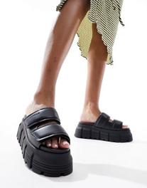 Oferta de Buffalo Ava Velari flat sandals in black por $132,99 en ASOS