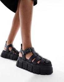 Oferta de Buffalo Ava Fisher flat sandals in black por $142,99 en ASOS
